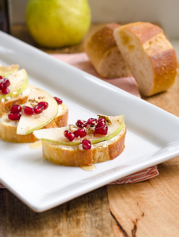 Pear, Pomegranate and Goat Cheese Crostini topped with Walnuts and Honey. | www.chicandsugar.com